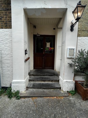 Path to doors. 4 steps up to doors. Handrail on left.