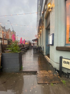 Pathway straight ahead. 1 step to left, built in ramp to right. From top of step or ramp, outdoor seating straight ahead, doors to right.