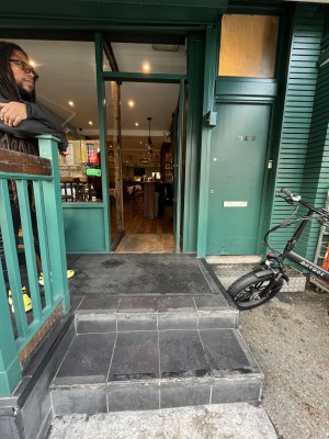 Single door with green doorframe. Push door open from the left.