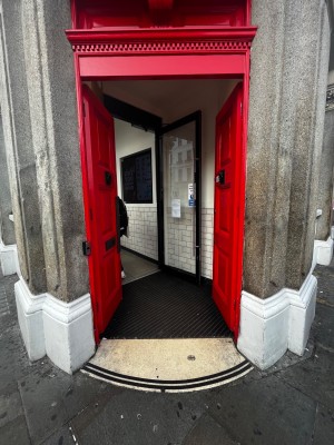 Red wooden double doors. Push in center to open.