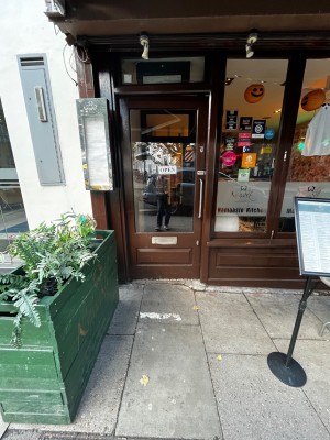 Glass door with brown frame. Push silver handle on right to open.