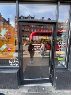 Glass door with black frame ahead. Push black metal handle on right to open.
