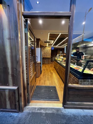 Glass door with brown frame. Push silver handle from right to open.