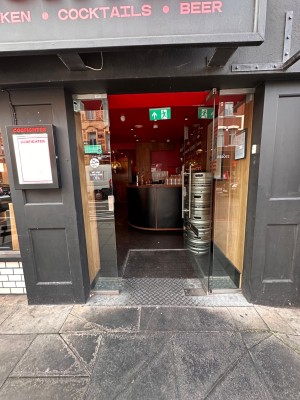 Glass door with silver, metal handle on left. Push to open.