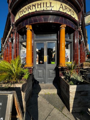 Glass double doors with grey frame. Push from middle to open. One step up to door.