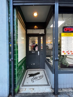 Open archway leading to glass door with grey frame. Push from right to open.