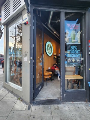 Glass door with blue, wooden frame. Push silver handle on right to open.