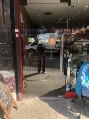 Glass door, push handle on right to open.  A-frame sign to left.