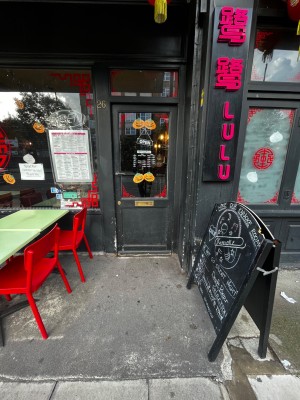 Glass door with black frame ahead. Push via handle on left to open.