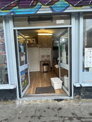 Double doors with white doorframe. Push open from the middle. Storage box obstructing door on right.