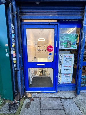 Glass door with blue frame. Push blue handle from right to open.