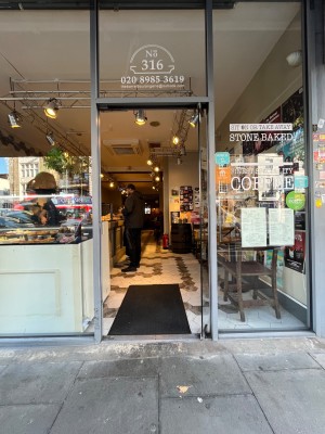 Glass single door. Handle on left. Push to open. Small bump at foot of door.