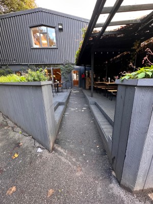 Path towards entrance straight ahead. Wall on both sides of path entrance.