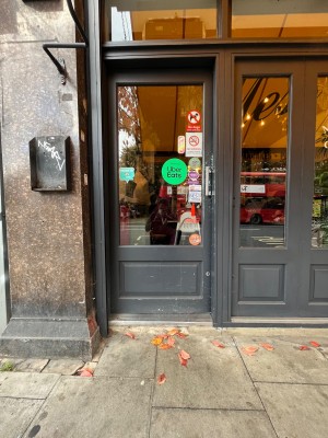 Glass door with dark grey frame. Push from right to open.