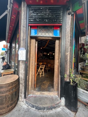 Glass door with brown, wooden frame. Push from right to open.