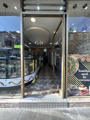 Glass door ahead. Push silver handle on left to open.