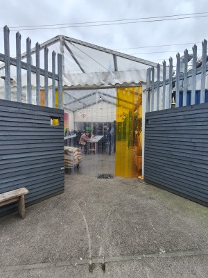 Blue gates before entrance. Pull or push from centre to open. Outdoor seating on left.