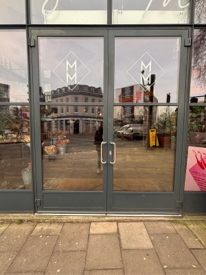 Double glass doors with black doorframe ahead. Pull metal handles at center to open.