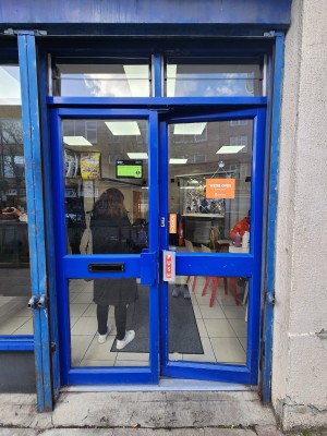 Double doors with blue border. Handles in center. Push to open.