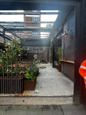 Open archway to main entrance doors from street. Doors on right wall ahead, outdoor front area on left.