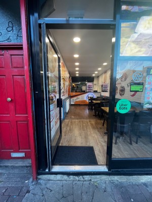 Glass door with black frame. One step up through door. Push from right to open.