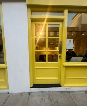 1 step followed by wood and glass door with handle on the right. Push.