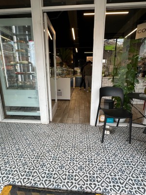 Single glass door within white frame. Push handle on right to open.