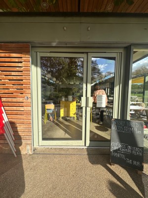Glass doors with light green doors ahead. Push via handle in center to open.