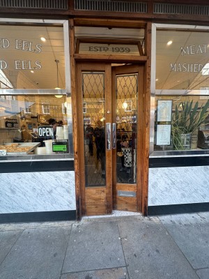Wooden framed glass doors. Push from centre to open.