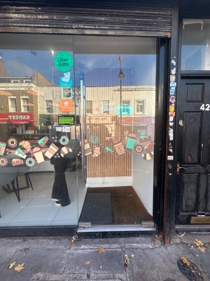 1 step followed by single glass door with handle on the left. Push.
