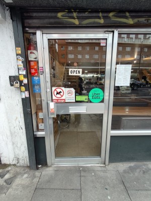 Silver framed glass door. Push silver handle on left to open.