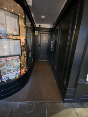 To right of venue. Open archway straight ahead. After archway, door on left wall.