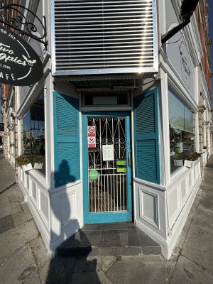 Opening ahead to glass door with blue frame on back. Push from right to open.