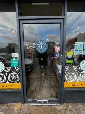 Glass door with grey frame. Push from right to open.
