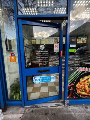 Glass door with dark blue frame. Push from right to open.