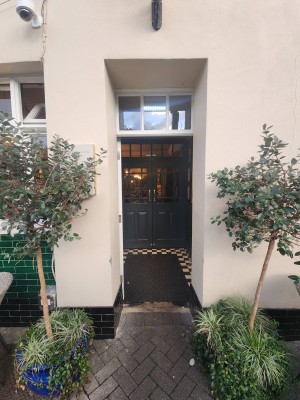 White door with glass panels ahead. Push from right to open.