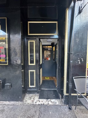 Built in ramp followed by wood and glass door. Handle on the right. Push to open.