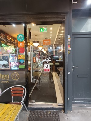 Glass door with silver, metal handle on left. Push to open.