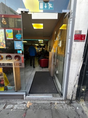 Glass door. Push from left to open. One step up through door.