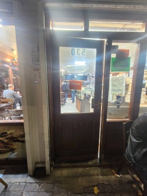 Wood door with glass window. Handle on right. Push to open.