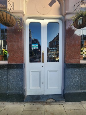 Glass doors with white frames ahead. Push from center to open.