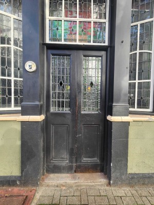 1 step followed by double wood and glass doors. Push.