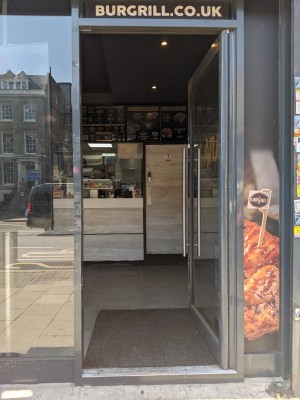 Glass door with metal frame and metal handle. Push from left to open.
