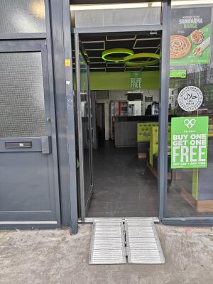 Glass door with dark metal frame. Push from handle on left to open.