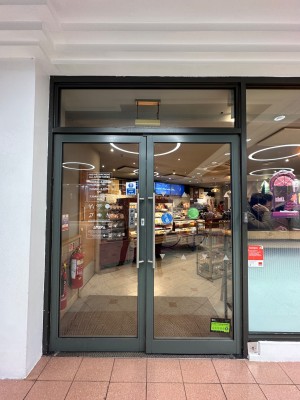 Glass double doors with grey frame. Silver handles in the middle. Pull to open.