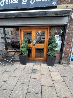 From street, outdoor seating area to left of doors.
