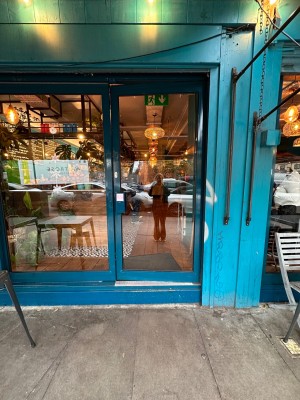 Glass door with blue metal frame. Push from left.
