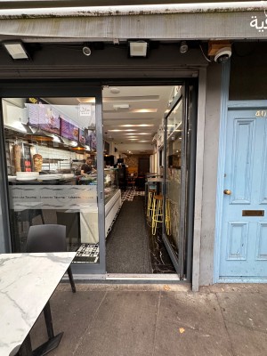 Glass door with grey frame. Push from left to open.