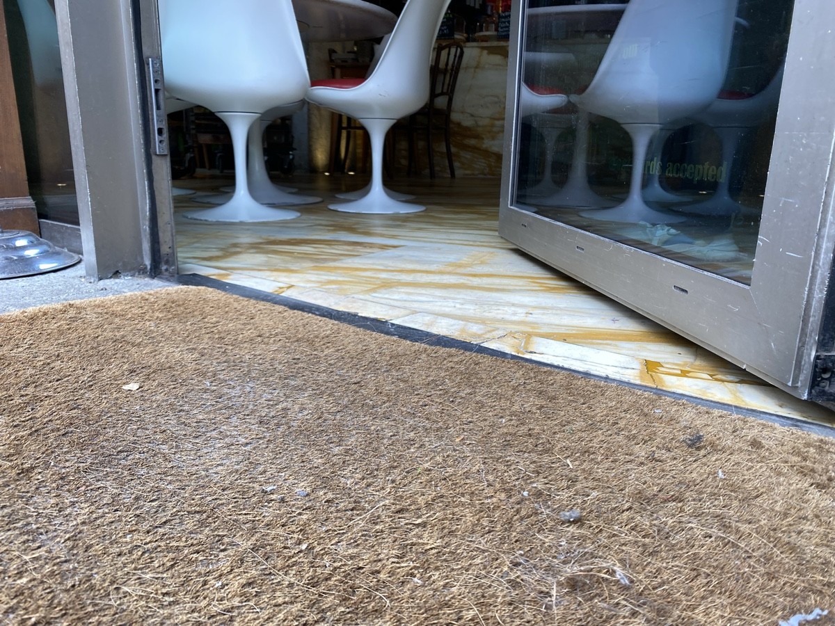 Small bump at foot of door. Doormat before bump.