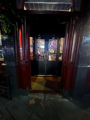 Glass double doors with dark red wooden frame. Push from middle to open.